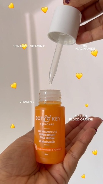 A close-up, hand-held shot of a Vitamin C face serum, using on-screen text labels to highlight key ingredients directly over the bottle.